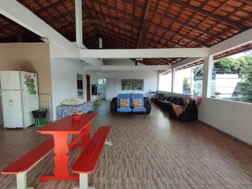 uma sala de estar com uma mesa vermelha e um sofá em Casa temporada Cocal/Praia de Itaparica-Vila Velha em Vila Velha