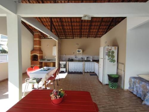 eine Küche und ein Wohnzimmer mit einem Tisch und einem Kühlschrank in der Unterkunft Casa temporada Cocal/Praia de Itaparica-Vila Velha in Vila Velha