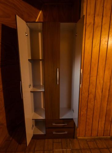 an open cabinet with shelves in a room at Domos El Llano in Putaendo