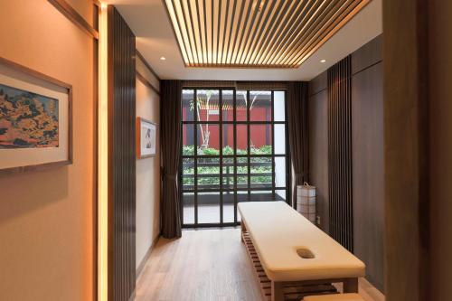 a room with a bench and a window and a table at Yoko Onsen Quang Hanh in Cẩm Phả