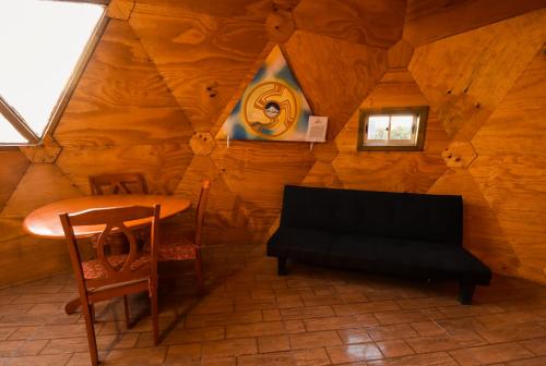a room with a table and a bench in a cabin at Domos El Llano in Putaendo