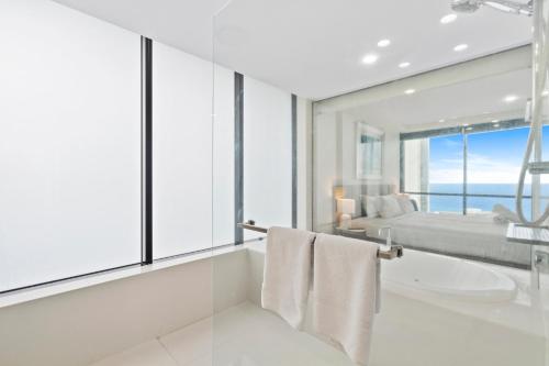 a bathroom with a tub and a sink and a bed at Circle on Cavill Contemporary Luxury and Spacious Three Bedroom Apartment in Gold Coast