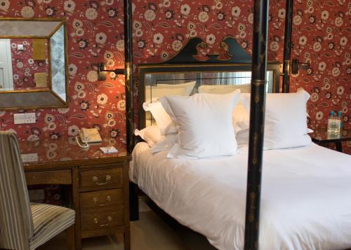 a bedroom with a bed and a dresser with a mirror at The Old Bridge in Huntingdon