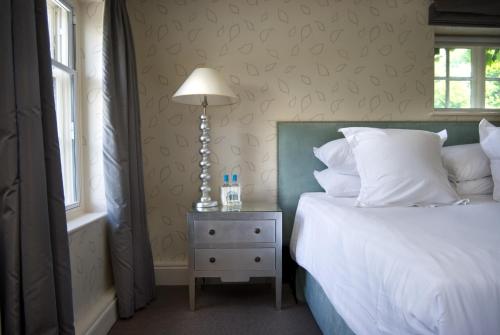 a bedroom with a bed and a lamp on a night stand at The Old Bridge in Huntingdon