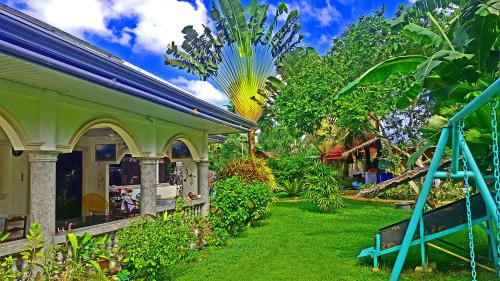 einen Garten neben einem Haus mit einer Palme in der Unterkunft MJ Room Rental Mahogany in Dauis
