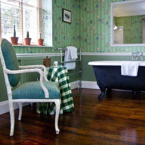 a bathroom with a chair and a bath tub at The Old Bridge in Huntingdon