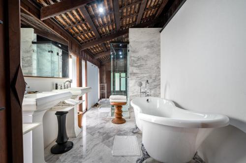 a bathroom with a tub and two sinks and a bath tub at Villa Mahabhirom - SHA Plus in Chiang Mai