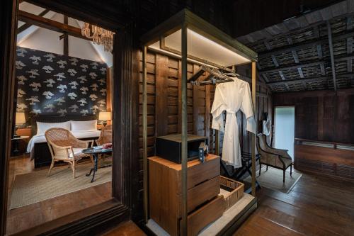 1 habitación con 1 dormitorio con mesa y 1 habitación en Villa Mahabhirom - SHA Plus, en Chiang Mai