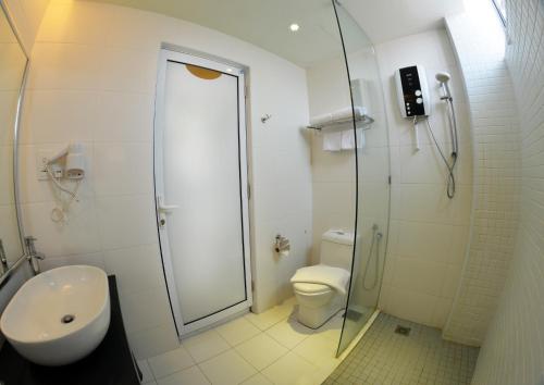 a bathroom with a shower and a toilet and a sink at Hotel Sentral Georgetown @ City Centre in George Town