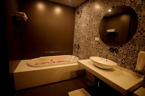 a bathroom with a tub and a sink and a mirror at The Opal in Rāmpur