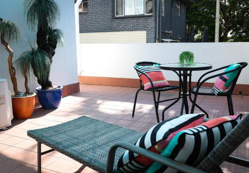a patio with a table and chairs on a patio at White Crest Apartments in Hervey Bay