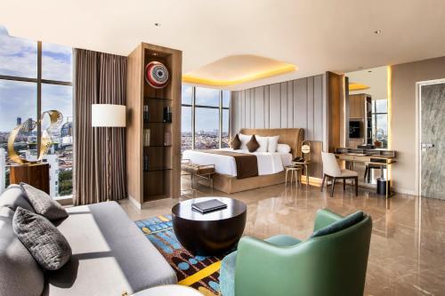 a hotel room with a bed and a living room at MORAZEN Surabaya in Surabaya