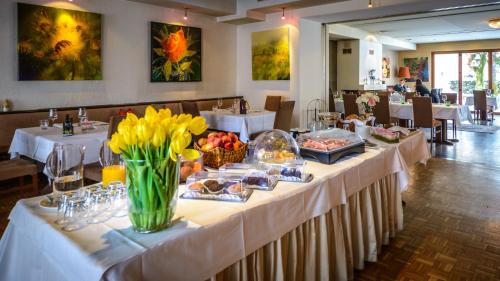 a long table with food and flowers in a restaurant at Hotel Restaurant Auerhahn in Salzburg