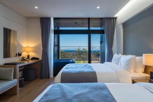 Cette chambre comprend 2 lits et une fenêtre. dans l'établissement Hotel Parangvue, à Goseong