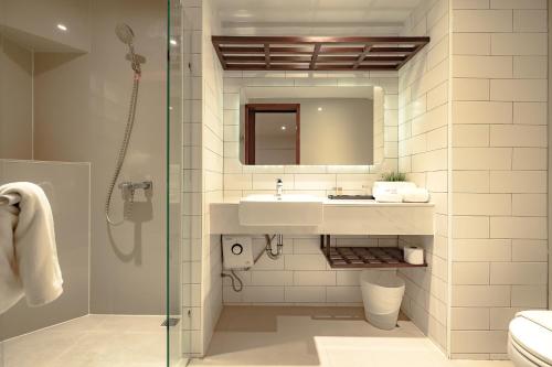 a bathroom with a sink and a shower at Coco Hotel in Bangkok