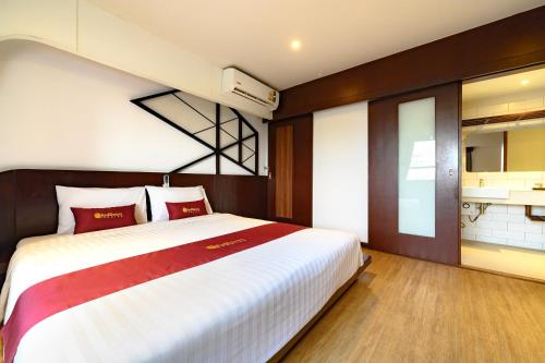 a bedroom with a large bed and a kitchen at Coco Hotel in Bangkok