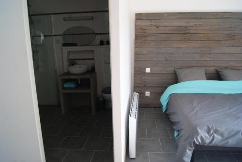 a bedroom with a wooden headboard and a bed at GrIsa'Home in Aisonville-et-Bernoville