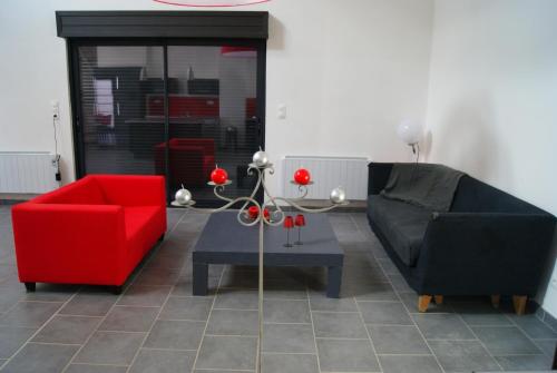 a living room with two chairs and a red couch at GrIsa'Home in Aisonville-et-Bernoville