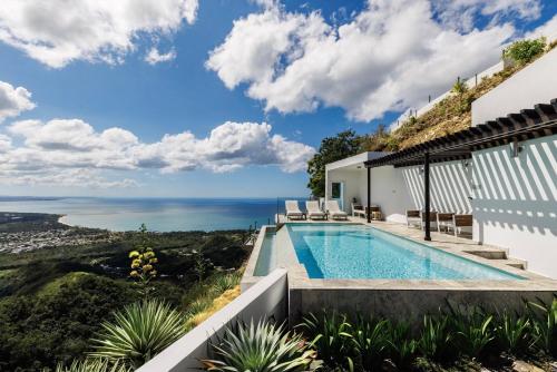 a villa with a swimming pool and a view of the ocean at Adults Only! Ocaso Luxury Villas Entire Property in Rincon