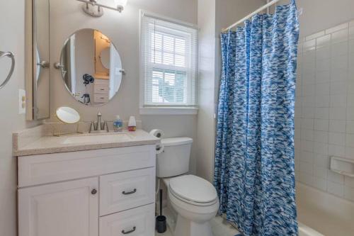 a bathroom with a toilet and a blue shower curtain at Stunning Vacation Home /Private Theatre/Fire pit in Fairfax