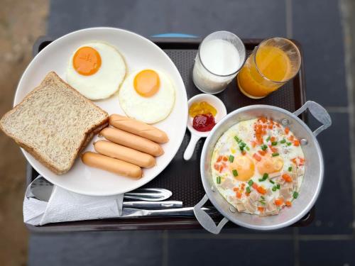 a tray with a plate of food with eggs and toast at Por Sampao Camp&Resort in Ban Pha Saeng Lang