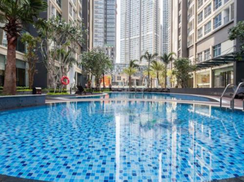 a large blue swimming pool in a city with tall buildings at Liam Service Apartment - Vinhome Central Park in Ho Chi Minh City