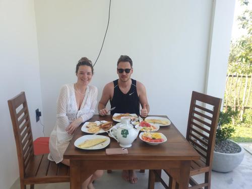 a man and a woman sitting at a table with food at Giri Villa in Tangalle