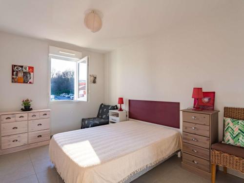sypialnia z łóżkiem, krzesłem i oknem w obiekcie Appartement moderne à 300m de la plage avec terrasse et parking sécurisé - FR-1-2-417 w mieście Hendaye