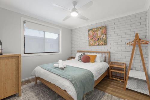 Un dormitorio con una cama grande y una ventana en Orion Retreat by Experience Jervis Bay, en Vincentia