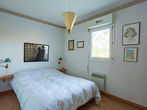 a bedroom with a white bed and a window at Appartement RDC avec terrasse, piscine et parking à 1km de la plage - FR-1-2-418 in Hendaye
