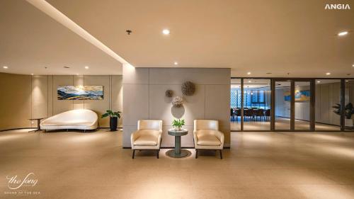vestíbulo del hotel con 2 sillas y 1 cama en The Sóng Apartment Vũng Tàu - Mita House, en Vung Tau