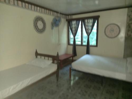 a living room with two beds and a window at WAI MAKARE HOMESTAY ROOM 2 in Naviti Island