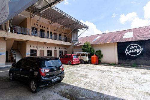 a car parked in a parking lot in front of a building at RedDoorz @ Jalan Sidomuncul 2 Jambi in Jambi