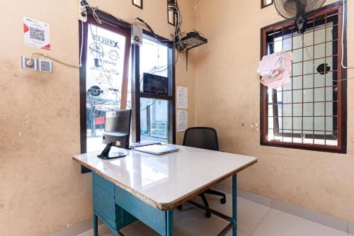 an office with a desk with a computer on it at RedDoorz @ Jalan Sidomuncul 2 Jambi in Jambi