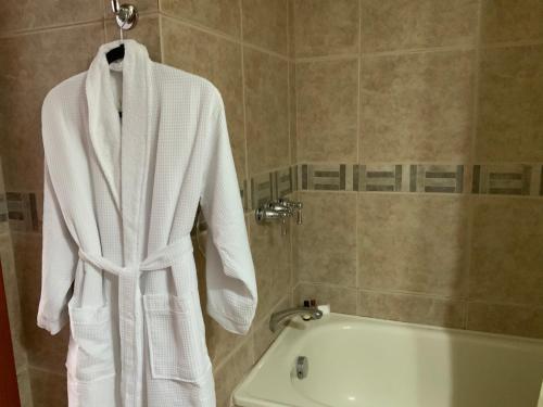 toalla blanca colgada en un estante del baño en Serenity Inn, en Quito