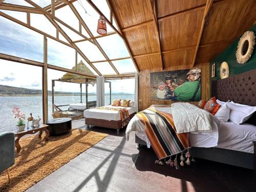 a bedroom with two beds and a view of the water at Hotel - Titicaca Dora in Puno