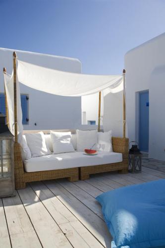 a white couch with a canopy in a room at Vencia Boutique Hotel in Mýkonos City
