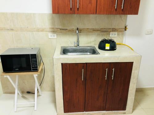 a kitchen with a sink and a microwave at Edificio Santa Isabel in Cali