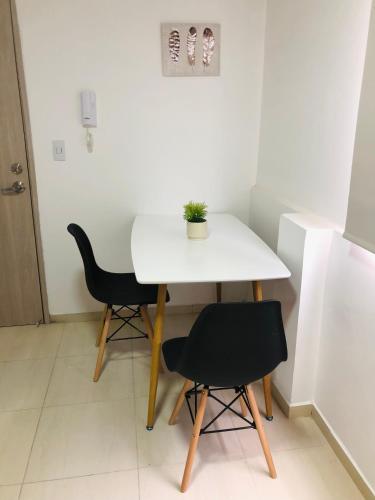 a small white table and two chairs in a room at Edificio Santa Isabel in Cali