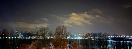 a city lit up at night with a city at Dnipo river Apart #з видом на Дніпро in Dnipro