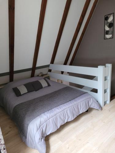 um quarto com uma cama branca e uma cabeceira em madeira em Gite Delphine em Kaysersberg