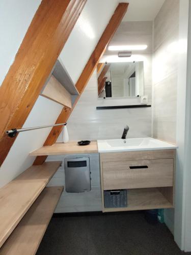 La salle de bains est pourvue d'un lavabo et d'un escalier. dans l'établissement Gite Delphine, à Kaysersberg