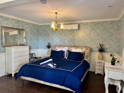a bedroom with a blue bed and a mirror at House of Mahalo BnB in Mapleton