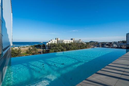 a swimming pool on the roof of a building with the beach at Hotel Parangvue in Goseong