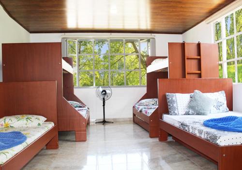 エル・コレヒオにあるFinca Hotel Villa Gladys en Mesitas del Colegioの二段ベッド2台と窓が備わる客室です。