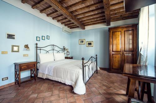 a bedroom with a bed and a table in a room at Corte Dell' Oca in Subbiano