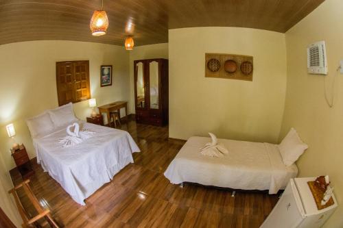 a room with two beds in a room at Evolução Ecolodge in Iranduba