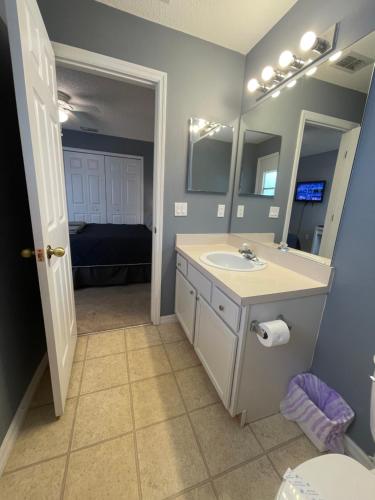 a bathroom with a sink and a mirror at 3 Bedroom Villa with Poolside Cinema and Games Room Close to theme Parks sleeps 6 plus 2 in Orlando