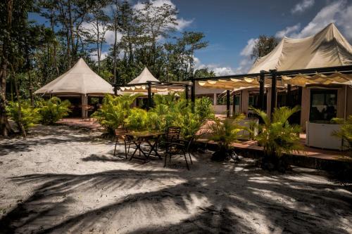 a resort with a table and chairs and tents at Canvas & Orchids Retreat in Tatai