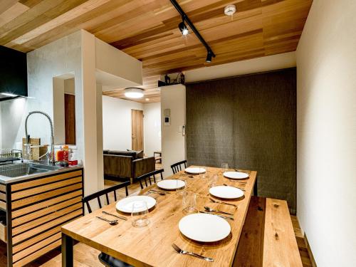 uma sala de jantar com uma mesa de madeira numa cozinha em Rakuten STAY HOUSE x WILL STYLE Yufuin Kawakami 103 em Yufu